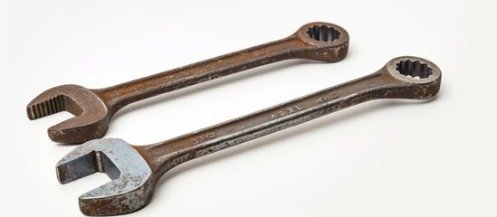 two rusty wrenches are sitting next to each other on a white surface . High quality