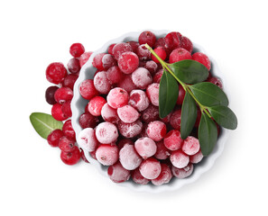 Frozen red cranberries in bowl and green leaves isolated on white, top view