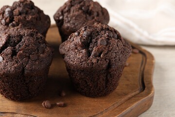 Delicious fresh chocolate muffins on white table, closeup. Space for text