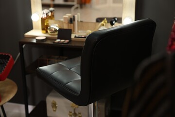 Makeup room. Chair near dressing table with different beauty products indoors