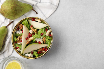 Delicious pear salad in bowl and fruits on light table, flat lay. Space for text