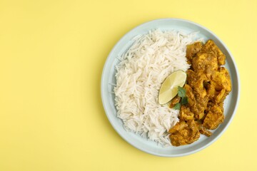 Delicious chicken curry with rice on yellow background, top view. Space for text