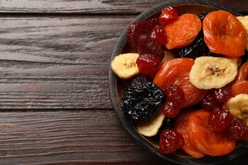 Mix of delicious dried fruits on wooden table, top view. Space for text