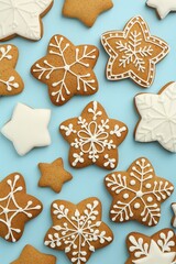 Tasty star shaped Christmas cookies with icing on light blue background, flat lay