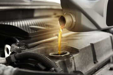Pouring motor oil into car engine, closeup. Color accent effect
