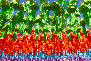 Colorful lanterns under a blue sky in Thailand during the Loy Krathong festival celebration.