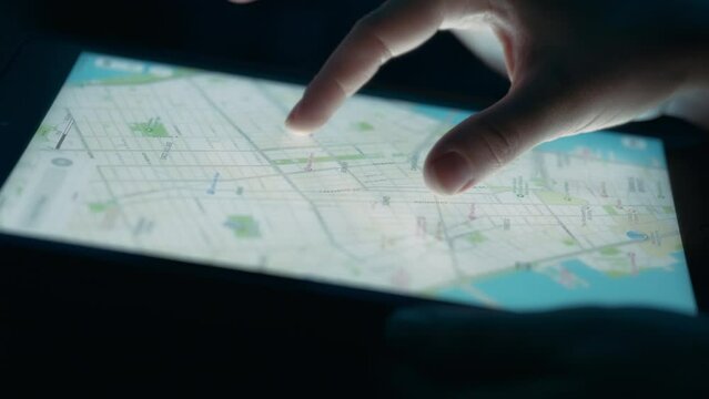 Person exploring a city map on a tablet touchscreen. Close up, slow motion. 
