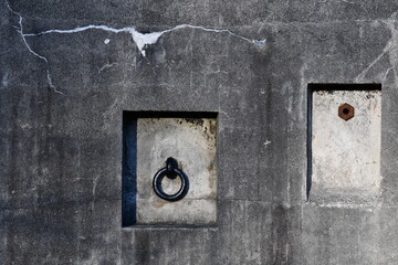 Iron rings on concrete bunker wall.