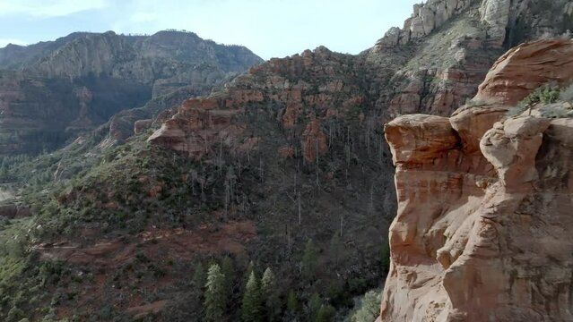 Red rock mountains and buttes in Sedona, Arizona with drone video moving forward close up.