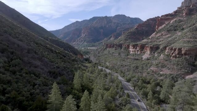 Highway 89A in Sedona, Arizona with mountains and cars driving with drone video moving up.