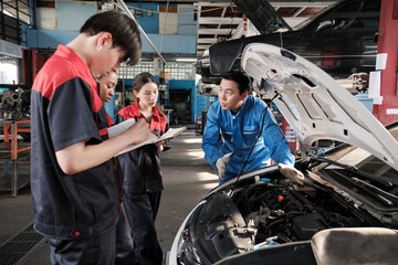 Asian male professional automotive engineer supervisor describes car engine maintenance and repair...