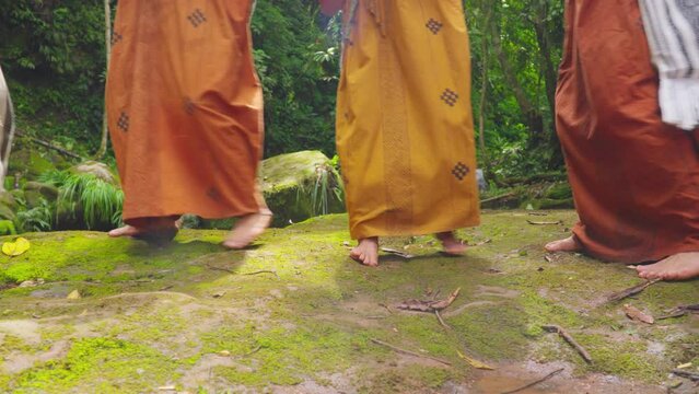 Barefoot individuals in traditional attire dancing on mossy ground in Oxapampa, Peru, forest backdrop