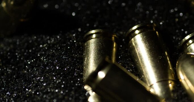Macro detail shot of 9&times;19mm Parabellum bullets sitting on gunpowder dust