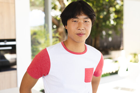 Teenage Asian boy stands confidently at home, with copy space