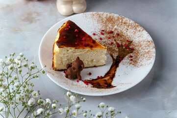 cheesecake on a plate on the table in a coffee shop.