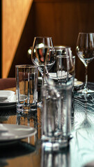 a wooden table with plates, glasses and silverware and wine glasses