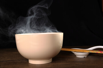 Smoke vape fog rising flowing out of miso soup black red white bowl on dark black background - 736742949