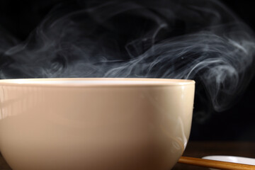 Smoke vape fog rising flowing out of miso soup black red white bowl on dark black background - 736743329