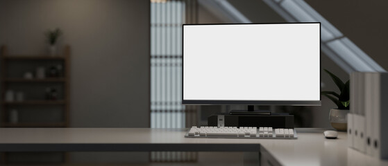 A modern office with a white-screen computer mockup and a keyboard on a table in a modern room.