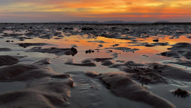 close up moment minimal sand beach landscape in sunset time colorful vivid marine sea landscape of orange color horizon scenic clods in sky small stream of tidal in Qeshm Island Iran adventure travel