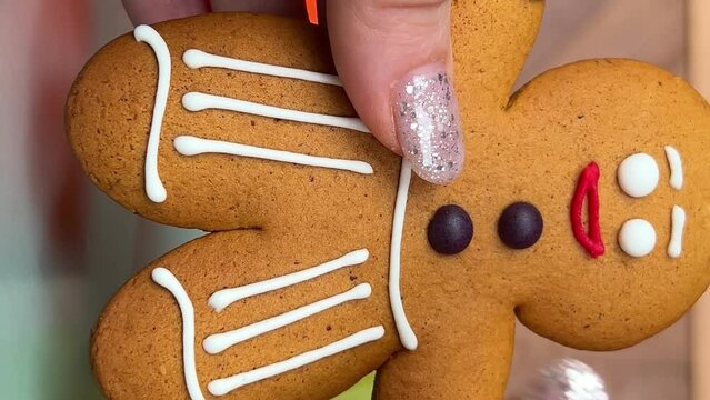 gingerbread man Gift for Christmas delicious cookies take out from packaging dance beautiful toy delicacy female hands with shiny Christmas manicure Present yami. symbol of winter New Year