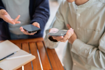 Two people sharing contact info or transferring files by bringing two smartphones close together.