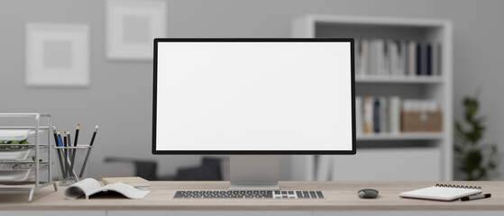 A white-screen computer mockup and office supplies on a wooden desk in a modern office.