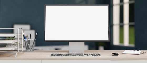 A white-screen computer mockup and office supplies on a wooden desk in a modern home office.