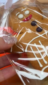 gingerbread man Gift for Christmas delicious cookies take out from packaging dance beautiful toy delicacy female hands with shiny Christmas manicure Present yami. symbol of winter New Year