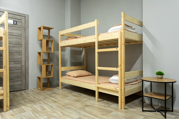 Wooden bunk bed , desk in large hostel  room - obrazy, fototapety, plakaty