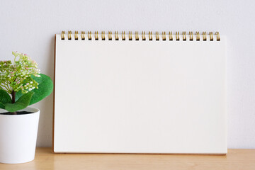 Blank notebook paper on table and white wall background