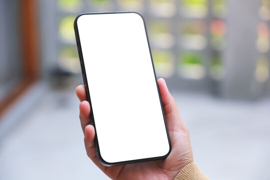 Mockup image of a woman holding mobile phone with blank desktop white screen