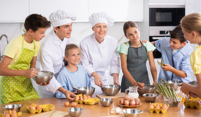 During lesson in cooking courses, female cook professional tells children about rules ticks and...