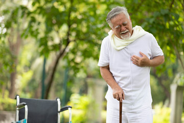 asian senior man suffering and having chest pain from heart attack in the park