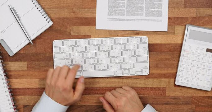 Male employee presses Escape key on keyboard at table
