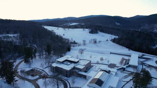 Ascending view of museum and hillside on a winter landscape among woodland scenery with luxurious, admirable architecture with a setting dusk sky. Williamstown, MA, New England, Northeast USA.