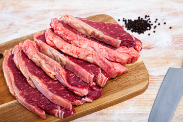 close up of pieces of striploin on wooden table