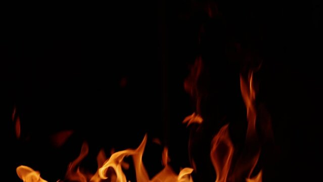 Fire burning. A bright burning fire on a black background. Fire in slow motion. Wall of fire, abstract background. Drag and Drop on Your Timeline, to apply a Fire effect to a video.
