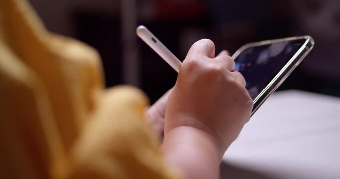 CLoseup of an individual cribbling some notes on a mobile tablet using an electronic stylus pen.