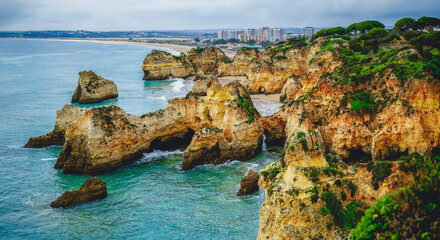 Panoramic view of the Algarve's rocky coastline, where cliffs meet the crashing waves of the...