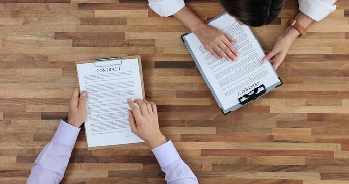 Partners compare points in commercial contracts at table