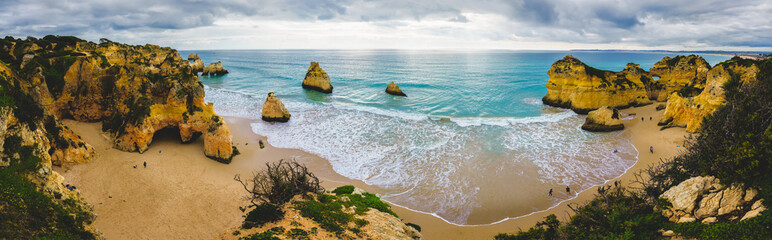 Rugged shoreline with natural arches and caves, crashing ocean waves, a dramatic beachscape,...