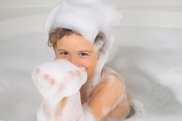 Kids face in foam. Happy funny kid bathed in the bath. Child in shower. Kids face in the bathroom...