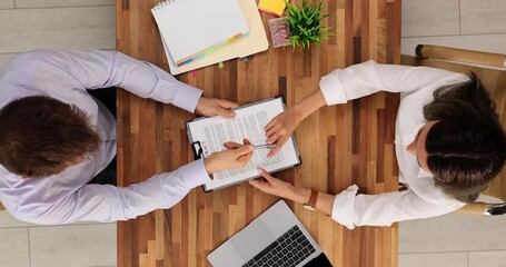 Male bank clerk gives contract to lady customer in office