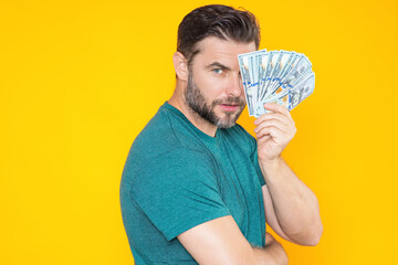 Man hold money on yellow studio isolated background. Rich man with money dollar bills. Successful...