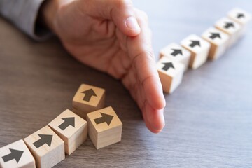Wooden blocks with arrow and hand. Delays and disruptions, stop the process, critical error concept