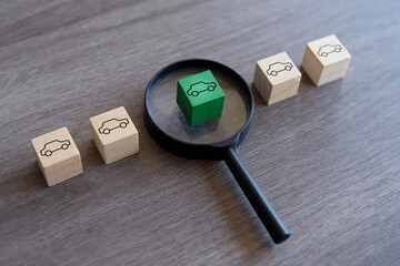 Wooden blocks with car icon and magnifying glass. Choose and buying a right car concept.