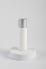 Plastic white tube for cream or lotion. Skin care or sunscreen cosmetic with stylish props on white background 