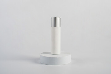 Plastic white tube for cream or lotion. Skin care or sunscreen cosmetic with stylish props on white background 