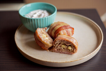 savory delight: delicious dish with meatballs wrapped in bacon, filled with mozzarella and yogurt sauce